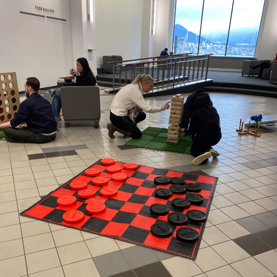 Two people playing Giant Jenga and two people playing Giant Connect 4 in the Games Lounge 