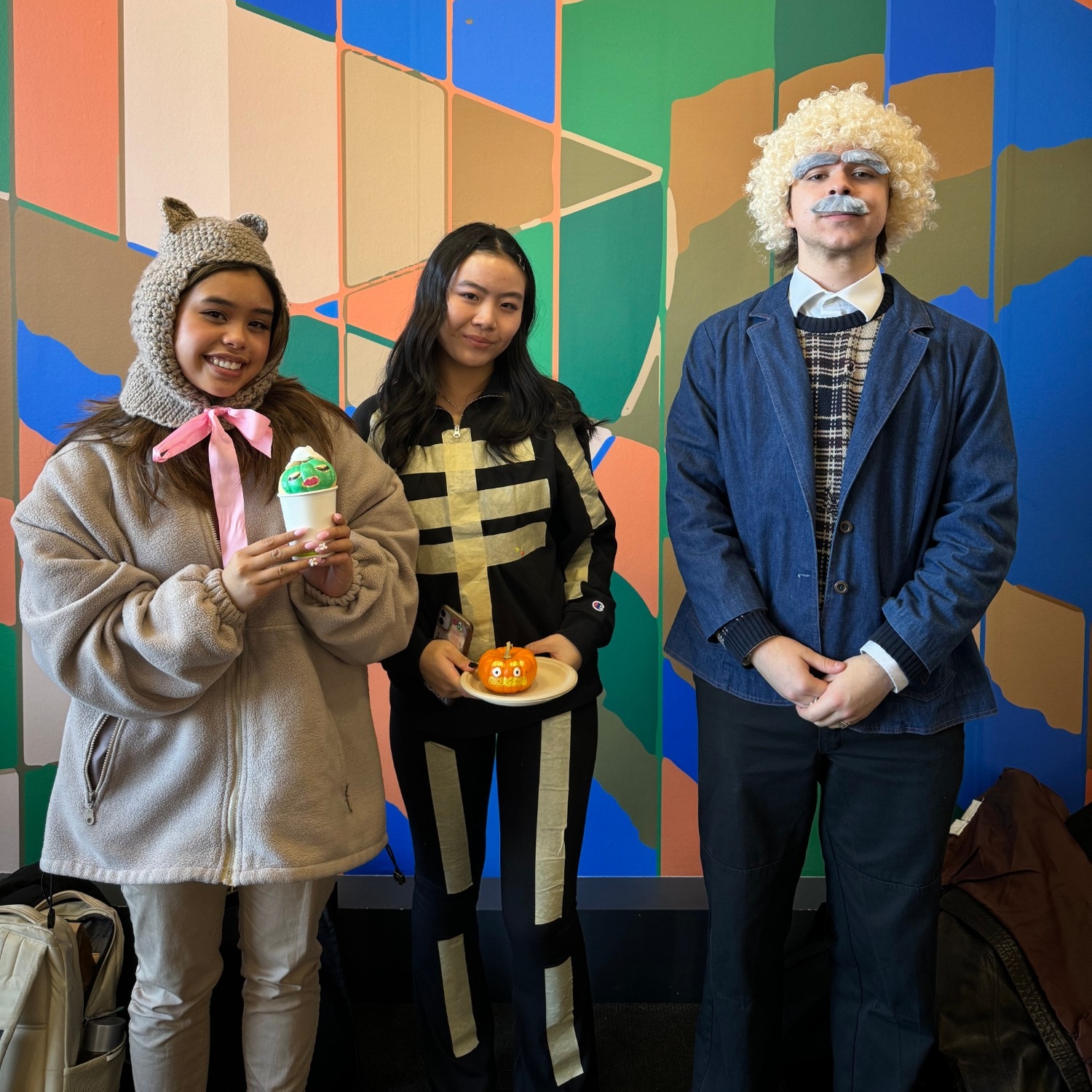 People dressed up as a bear, a skelelton, and Albert Einstein at 2023 Halloween Social