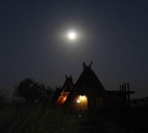 Chalets at !Xaus Lodge illuminated by the full moon. At night, the lodge receive