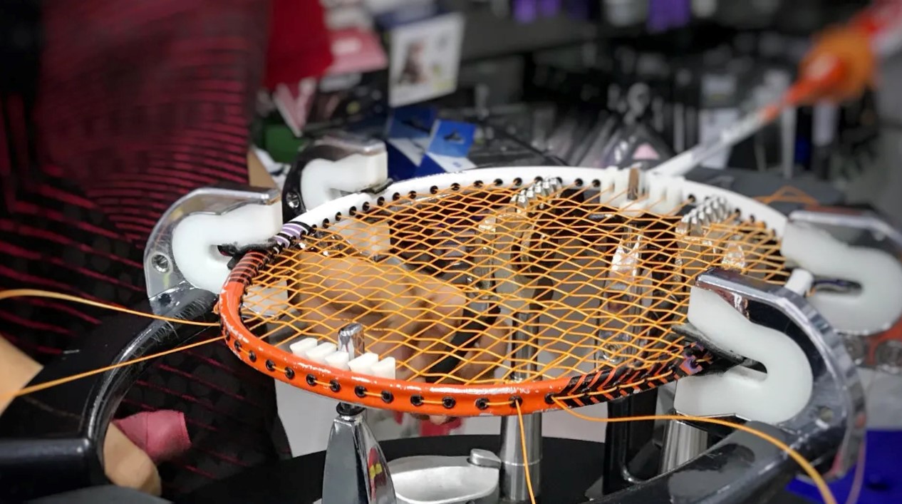 racket being strung by stringing machine