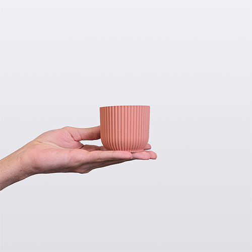 A hand holding a small pink plant pot. This image links to Ribu (Small)'s product details page.