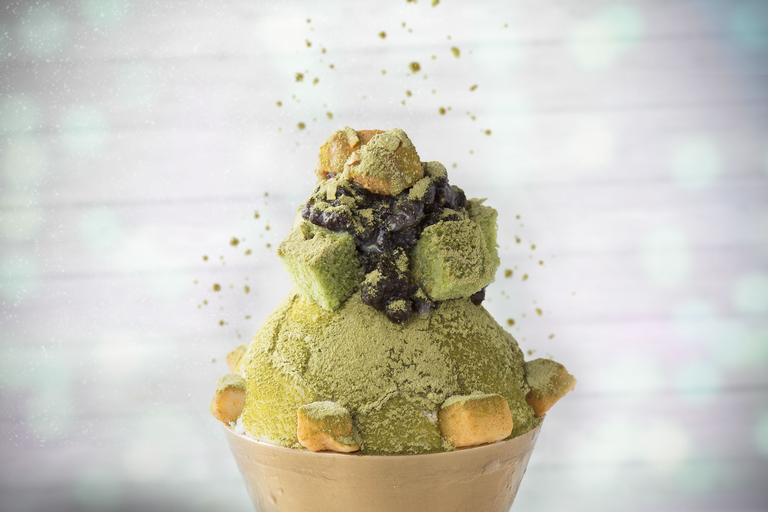 An appetizing shaved ice dessert with matcha topping sprinkled.